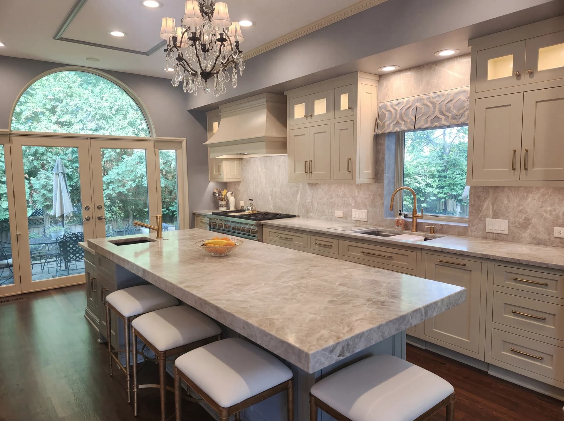 Elegant kitchen with marble countertops, island, and cabinets.